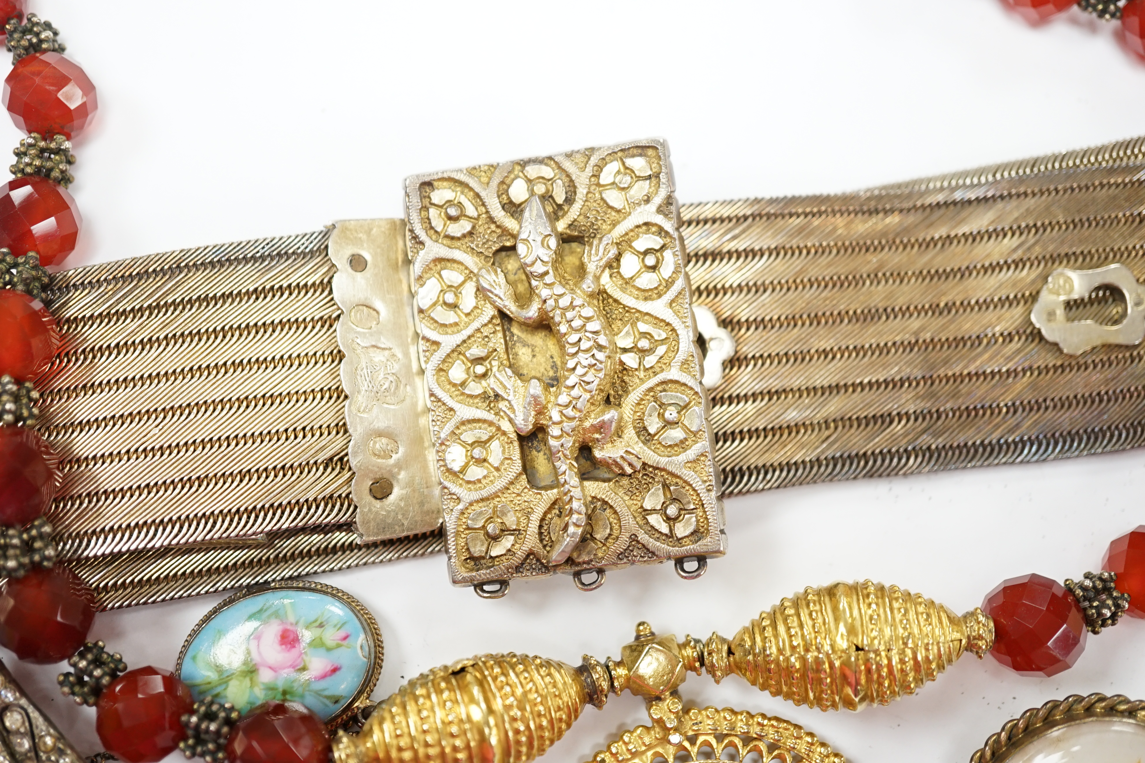 A group of assorted jewellery, including a Persian gilt white metal belt and a French gilt white metal and graduated porcelain plaque set bracelet. Fair condition.